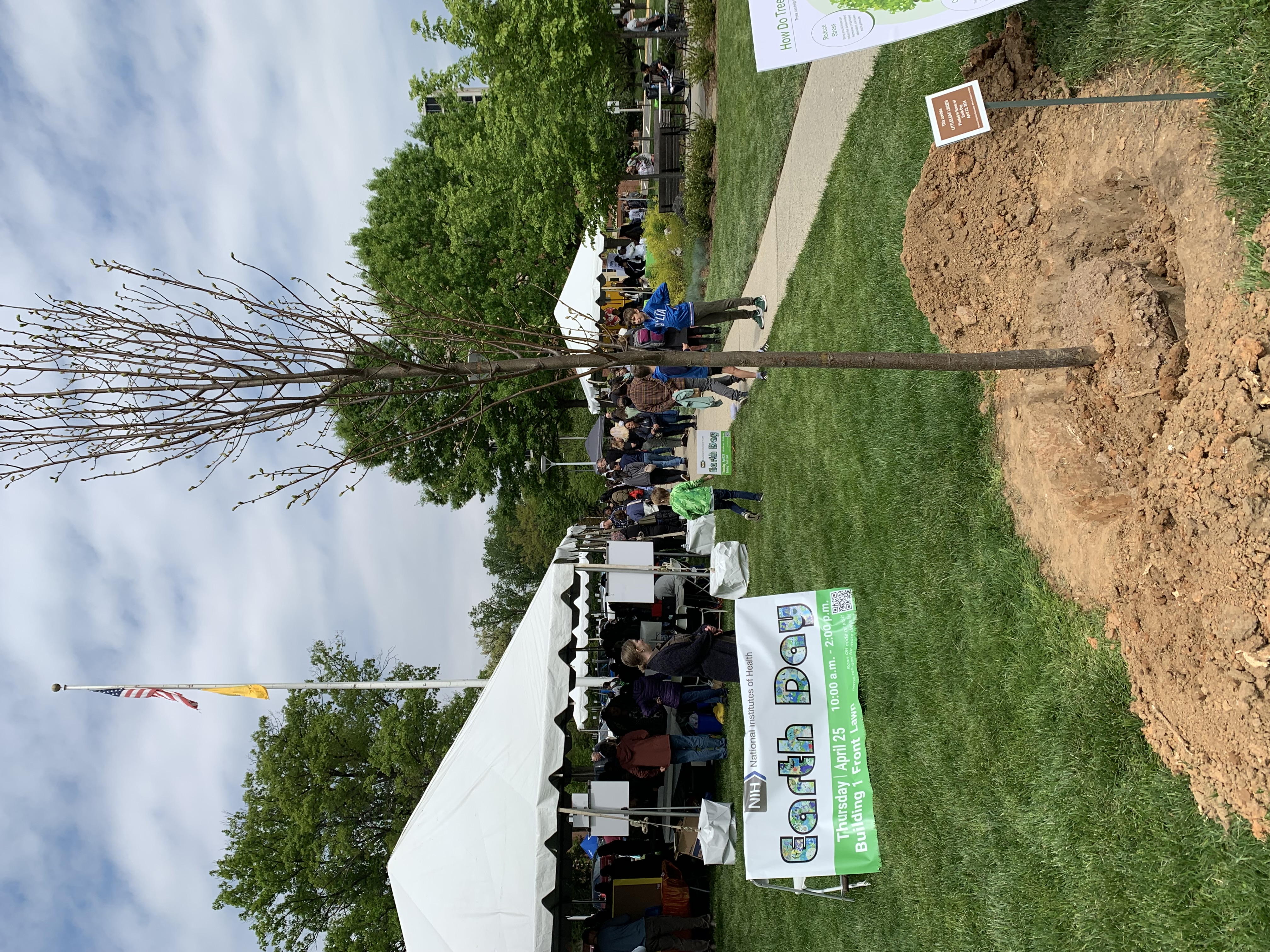 Picture of tree planting and banner at the 2024 NIH Earth Day